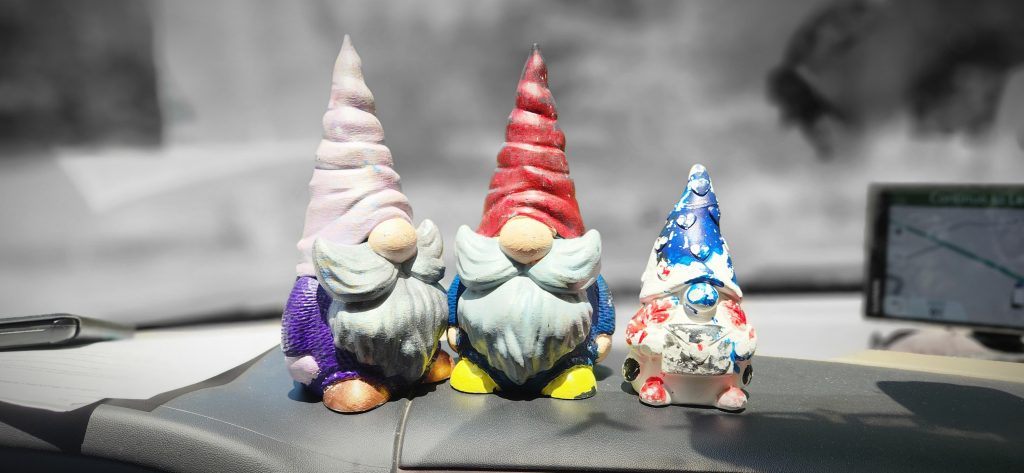 three gnomes on the dash of a truck